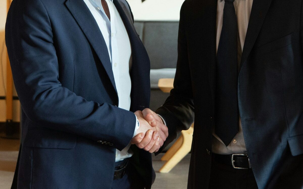 Jabat tangan dua profesional berjas di kantor